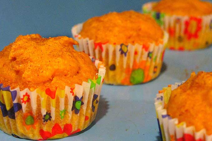 Four pumpkin muffins in cupcake wrappers | Foodal