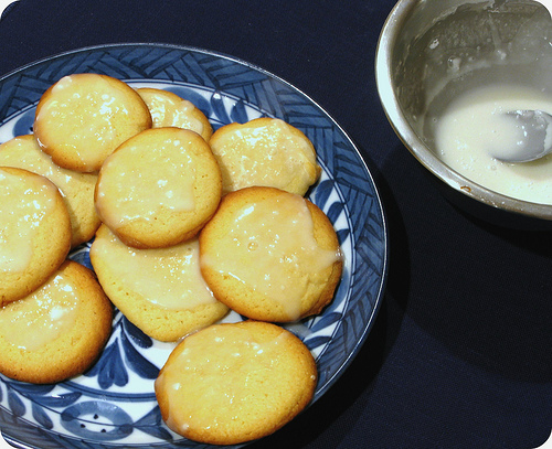 A plate of glazed lemon cookies on a black background | Foodal