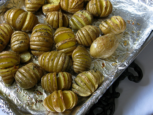 Cooked Saged Hasselback potatoes on a baking sheet | Foodal