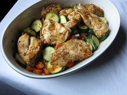 Top view of a white porcelain oval bowl full of Savory Low-Calorie Spiced Chicken | Foodal