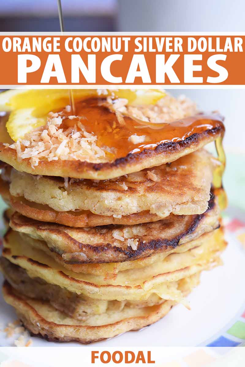 Vertical close-up image of a tall stack of pancakes covered in syrup, coconut flakes, and orange slices, with text on the top and bottom of the image.