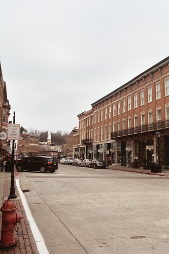 A view of a road flanked by red brick buildings.
