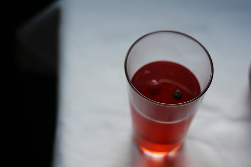 A top view image of a glass filled with kombucha tea flavored with berries.