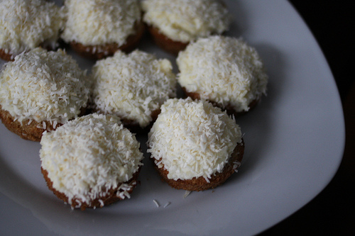 A top view image of coconut cupcakes with coconut flakes on top.