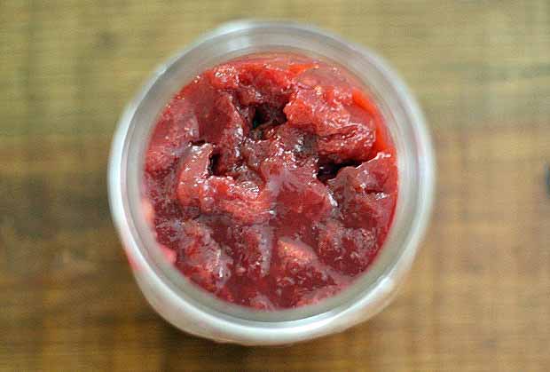 Top down view of a mason jar full of strawberry basil jam.