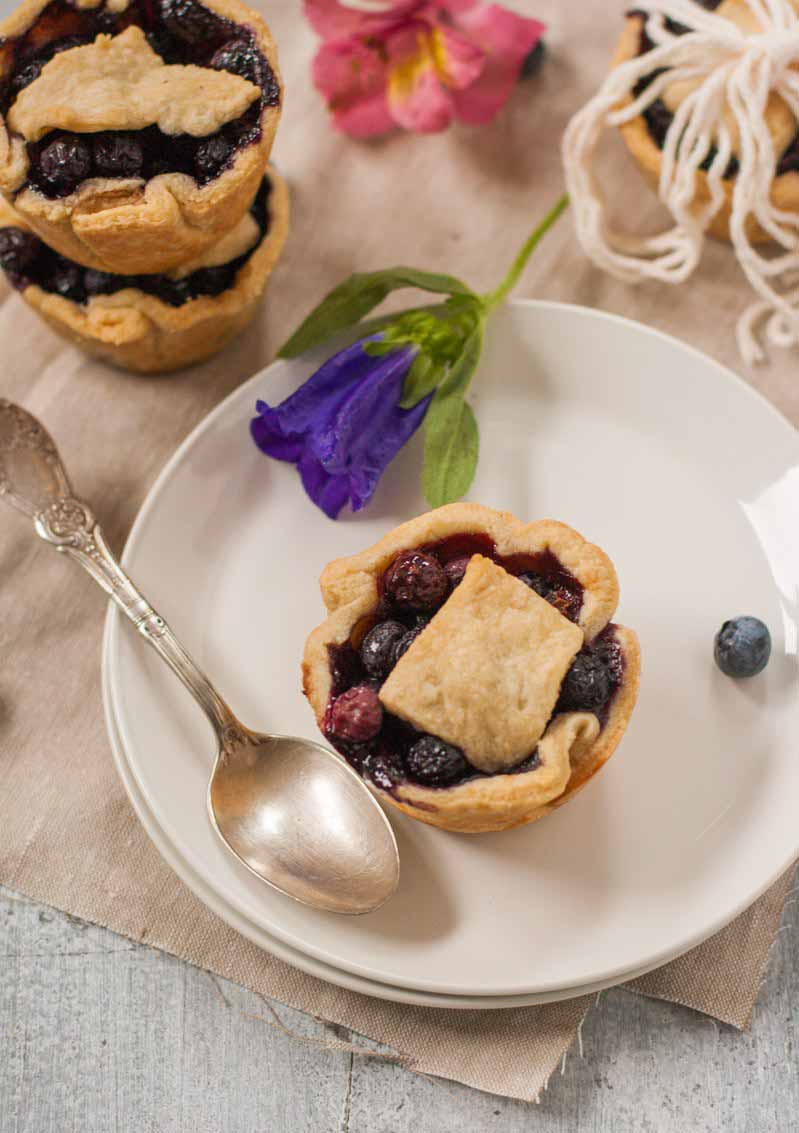 Top-down view of mini berry galette on a white porcelain plate.