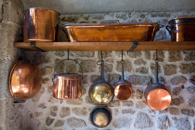 Copper Pots and Pans hanging on chateu wall in Normandy