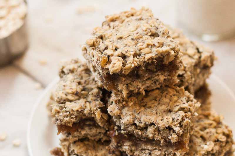 A close up of a stack of nutritious gluten-free and vegan breakfast bars that are made with whole ingredients and are similar to fig newtons.