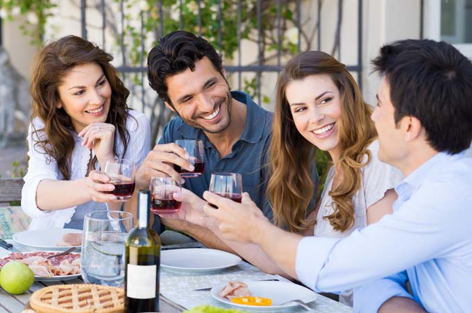Group Of Happy Young Friends Toasting Wine Glass Outdoors at party