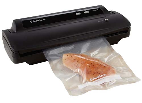 Foodsaver V2244 Vacuum Sealing System with chicken breast sealed on an isolated background