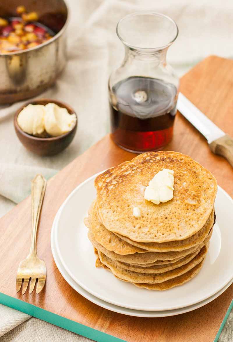 A stack of homemade spiced pancakes with a pat of butter on top.