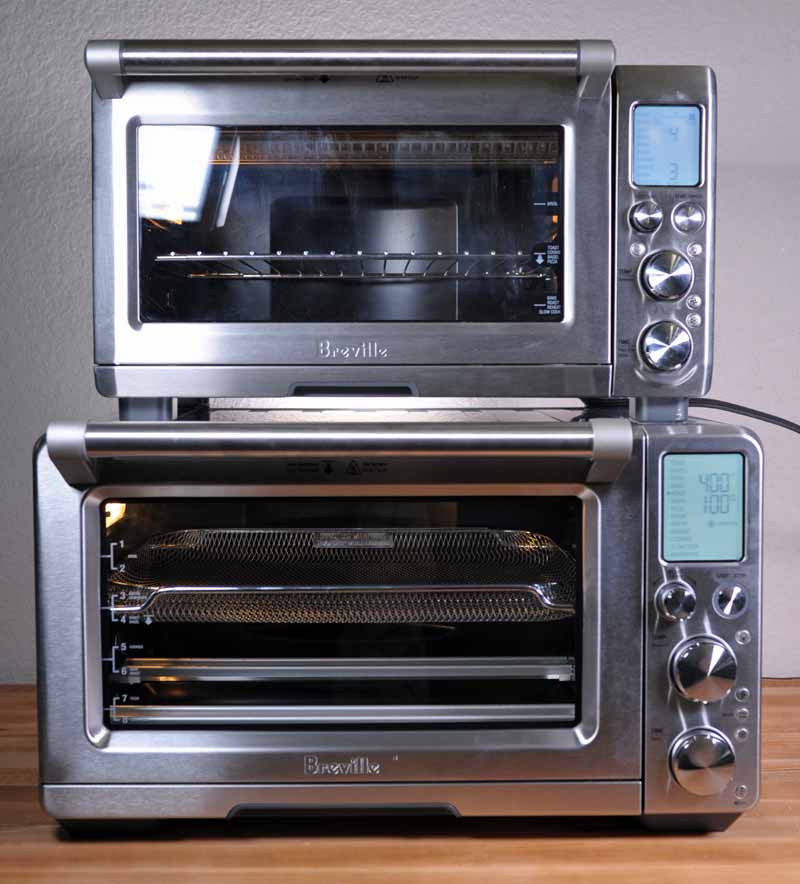 The older BOV800XL Smart Oven Pro stacked on top of the Breville BOV900BSS Smart Oven Air and demonstrating the size differences.