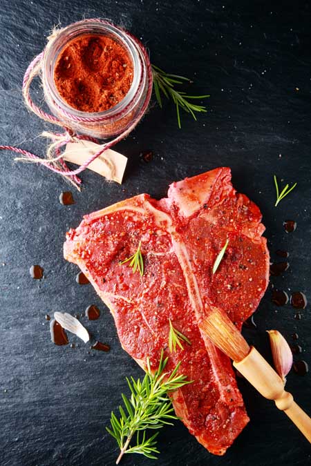 Beef bouillon spread on T-bone to augment natural MSG | Foodal.com