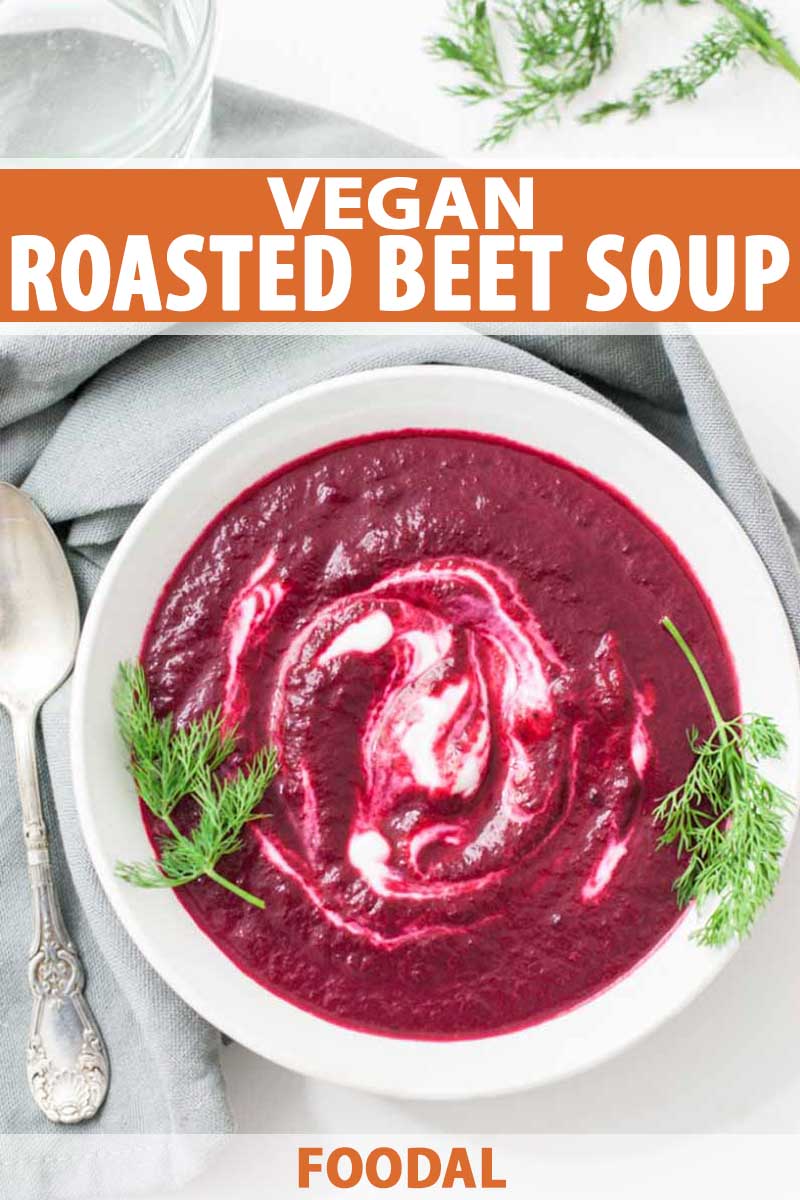 Close up top view of a bowl of vegan-friendly roasted beet soup with sprigs of green parsley.