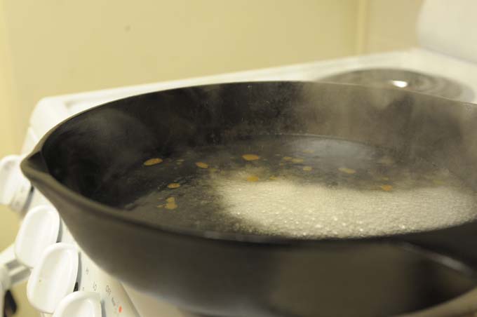 Boiling water to clean cast iron frying pan | Foodal.com