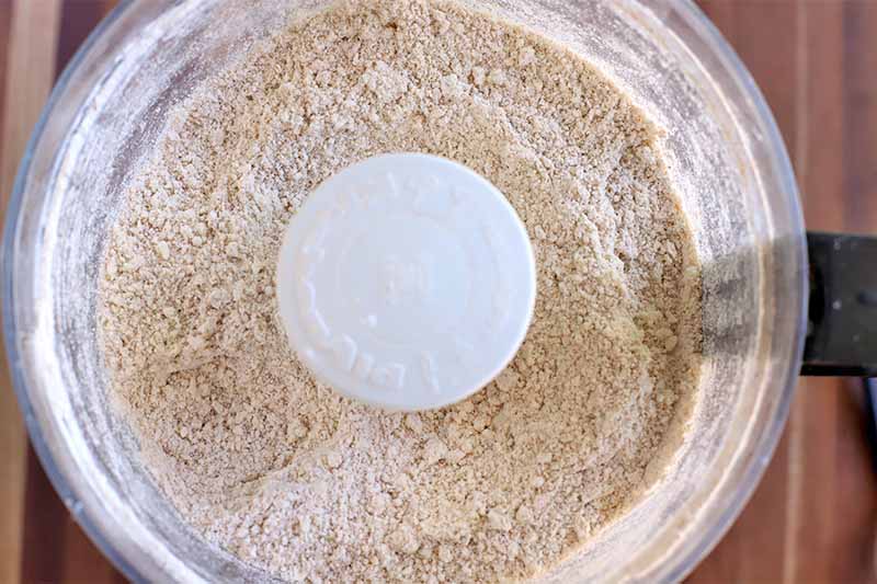 Top-down shot of a dry flour mixture in a food processor.
