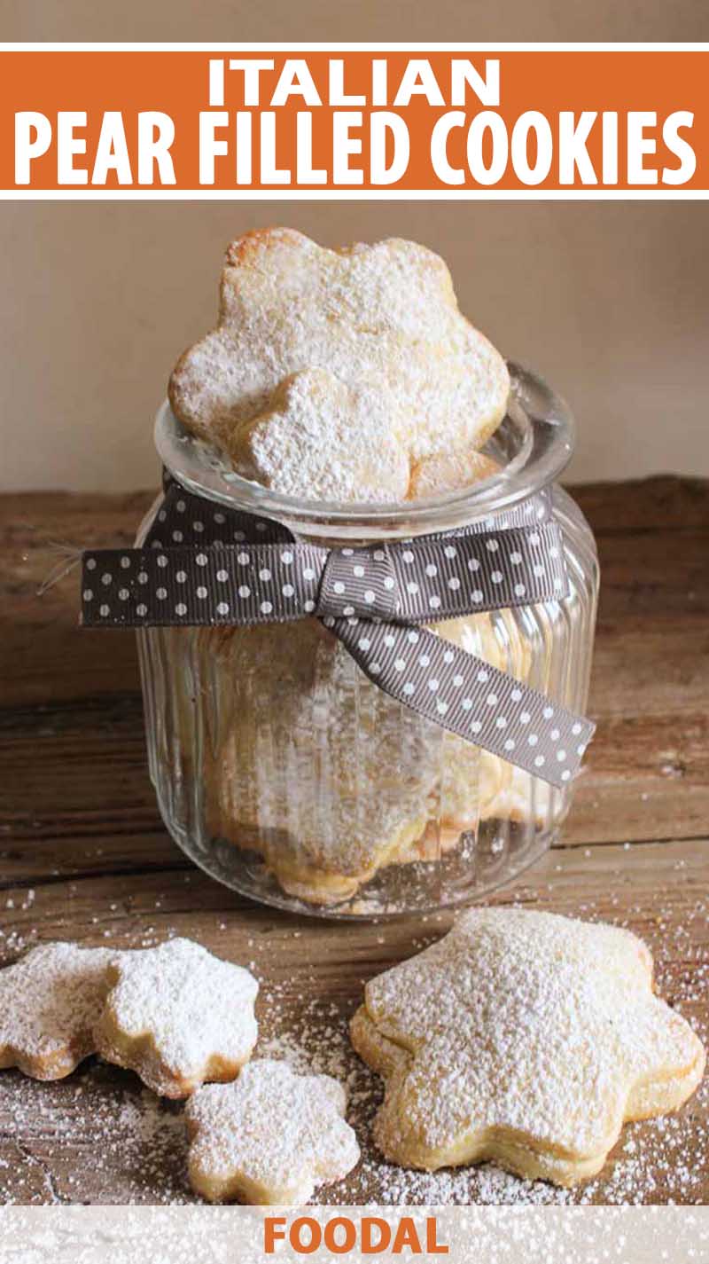 Italian Pear Filled Cookies in a glass jar with other cookies on a wooden table.