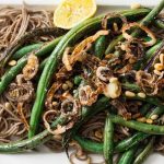 top down close up of a vegan-friendly and gluten-free side dish made with green beans, buckwheat soba noodles, and shallots.