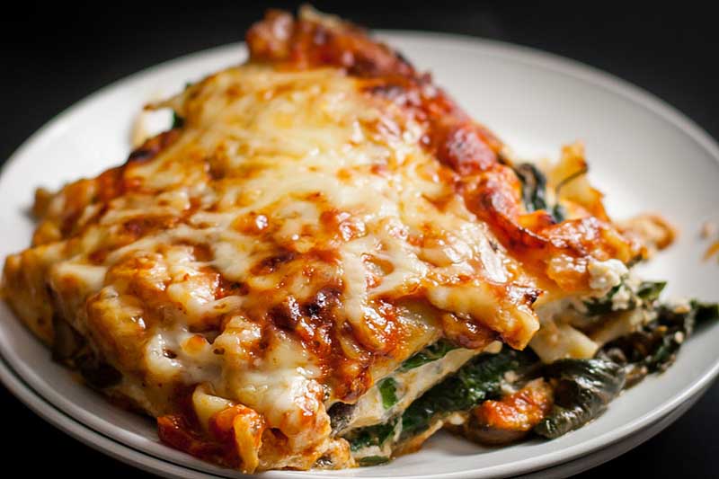 A close up of a piece of cheesy vegetarian lasagna.