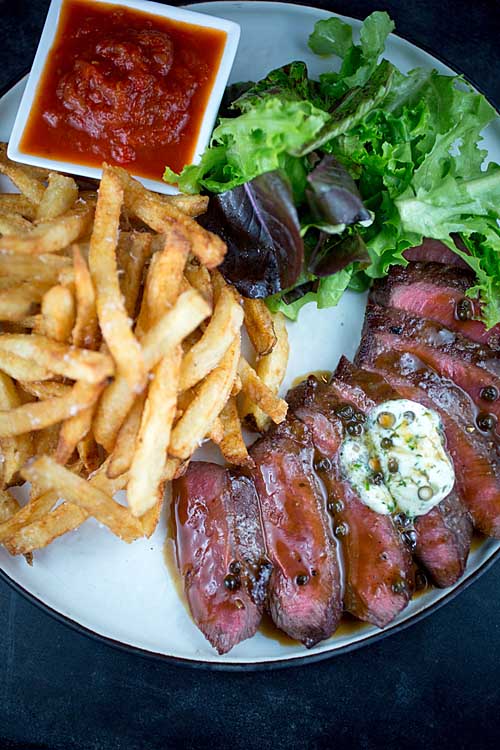 Flat Iron Steak with chimichurri sauce and french fries | Foodal.com