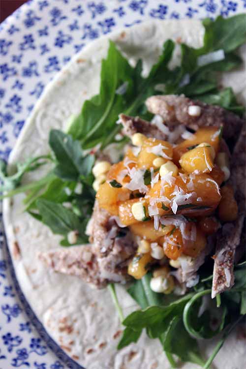 Juicy, marinated grilled pork topped with a dollop of cool sour cream and fresh corn and peach salsa - the perfect dinner for Taco Tuesday! Get the recipe: https://foodal.com/recipes/mexican-latin-america/pork-tacos-peach-corn-salsa/