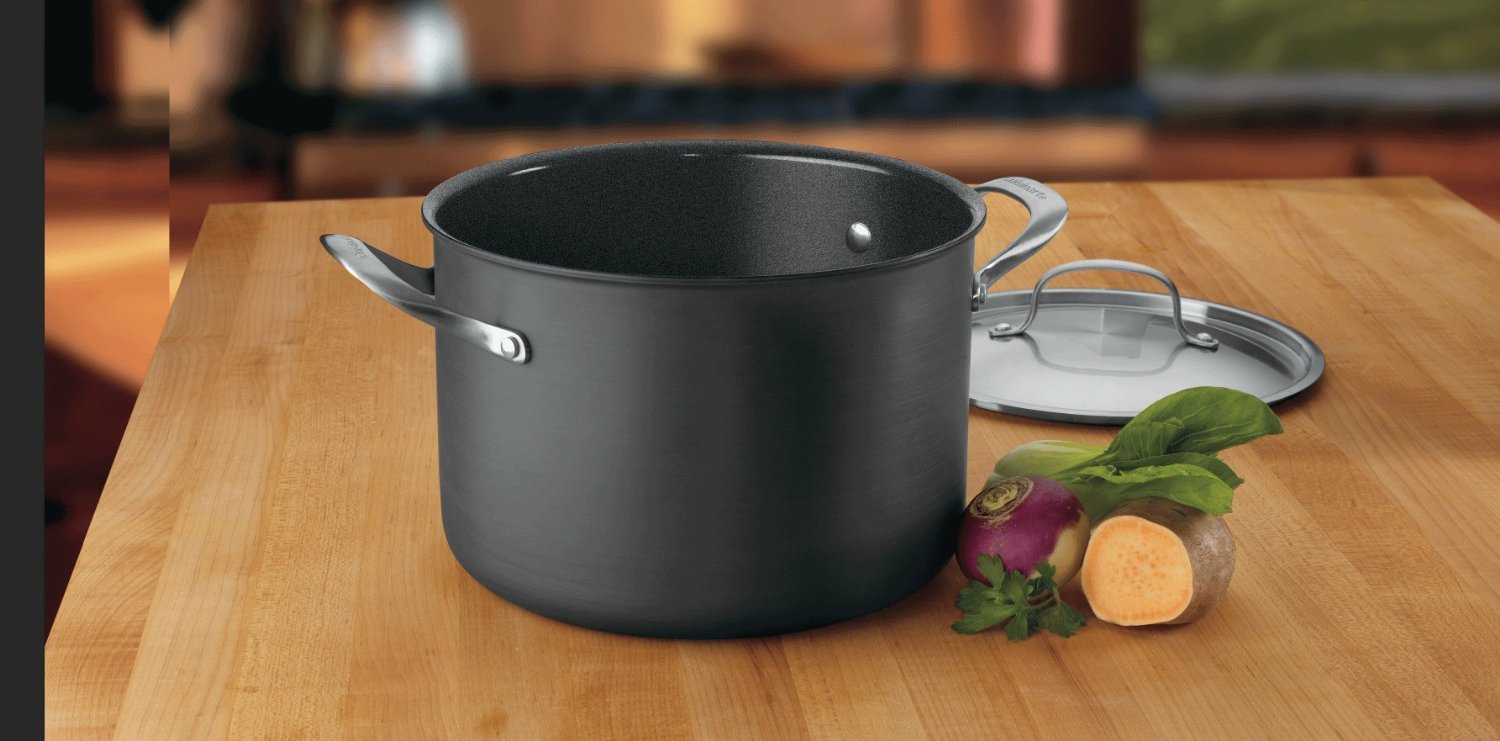 Cuisinart GG66-22 pot beside a sweet potato and herbs, with a lid in the background, on a butcher block countertop.
