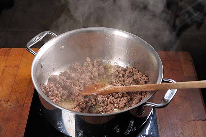 Ground Lamb being browned in a stainless steel stock pot.