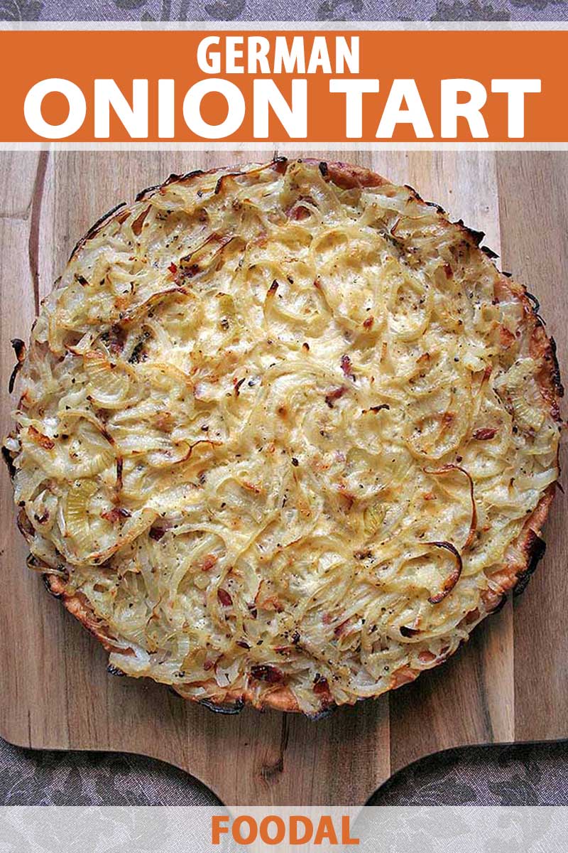 Top down view of a German onion tart on a wooden cutting board.