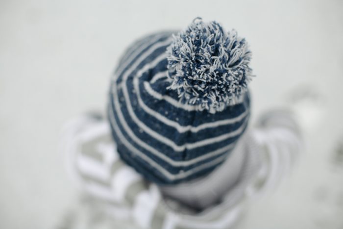 Top-down view of a young child in a stocking cap outside in the snow.