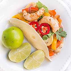 Homemade shrimp fajita topped with cilantro and red jalapeno slices, and a squeeze of lime. | Foodal.com