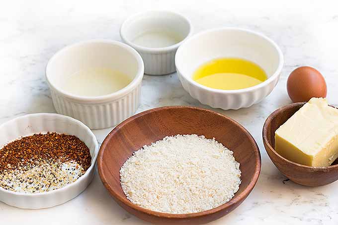Mise en place is important when prepping to make a recipe, so measure all of the ingredients required to make our classic baked shrimp scampi before you get started: breadcrumbs, salt, black pepper, red pepper flakes, lemon juice, white wine, olive oil, an egg, and butter.