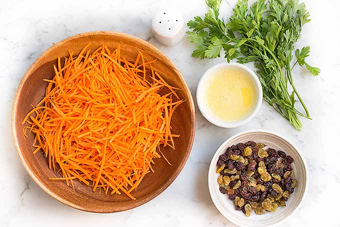 Make your own delicious salad at home with julienned carrots, brown and golden raisins, fresh lemon aioli, salt, and flatleaf parsley. | Foodal.com