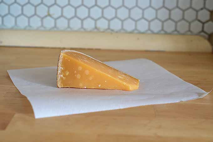 A wedge of cheese before it's properly wrapped in paper | Foodal.com