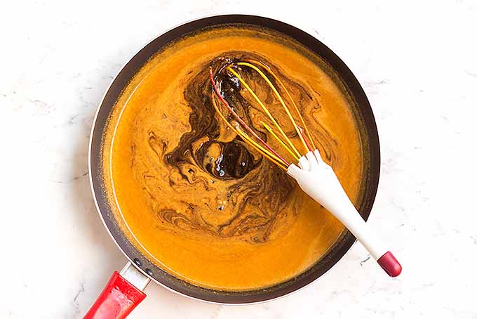 Whisking tamarind paste into a peanut sauce for a chicken satay dipping sauce. | Foodal.com