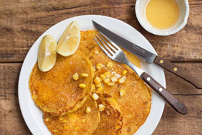 A plate of sweet cornmeal pancakes topped with honey. | Foodal.com