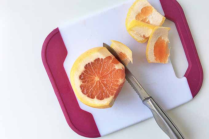 Cutting away the skin of a grapefruit. | Foodal.com
