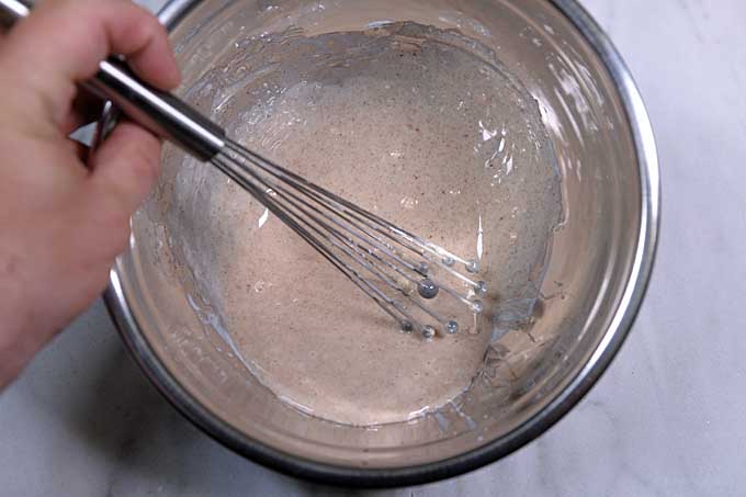 The glaze being whisked in a stainless steel mixing bowl.