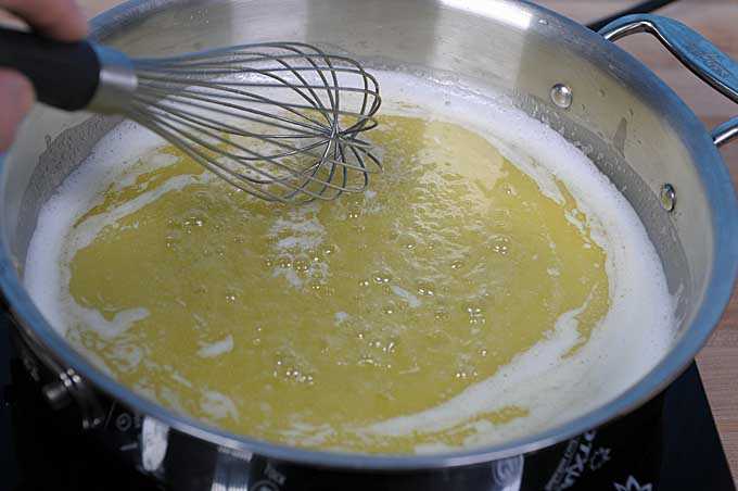 A saute pan with butter being heated and whisked | Foodal