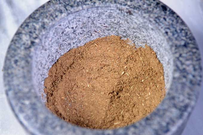 A mortar full of fully ground homemade poultry seasoning | Foodal