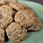 A pile of oatmeal chocolate chip cookies on a green circular place mat | Foodal