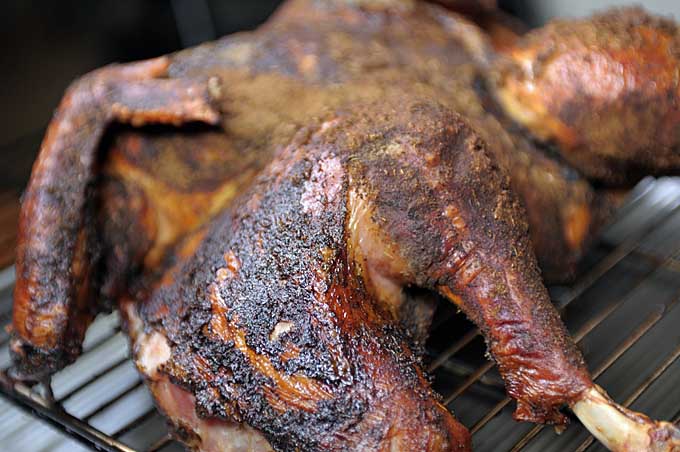 A close up of the leg of a rubbed and splatchcocked turkey | Foodal