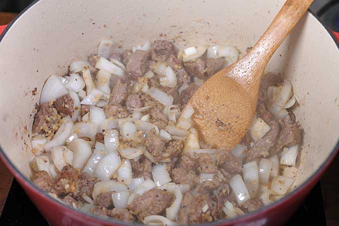 Onions being sauteed with lamb in a Dutch oven | Foodal 