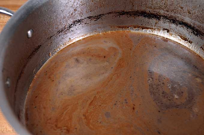 A completed au jus sauce in a stock pot | Foodal