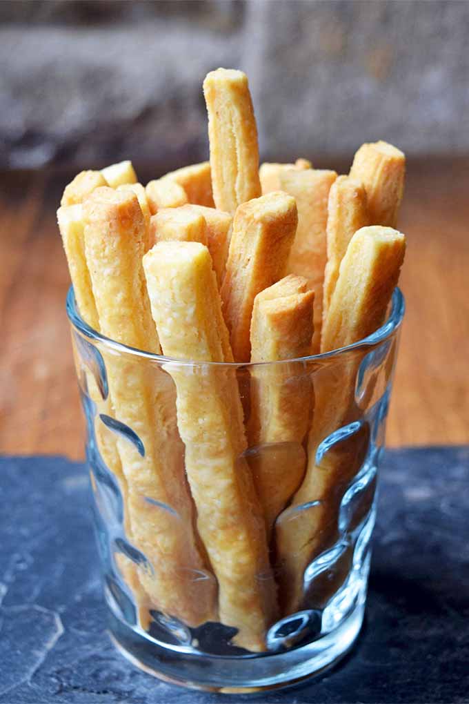 A glass filled with homemade cheese straws.