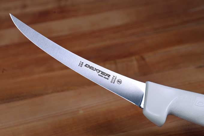 Dexter-Russell Sani-Safe Flexible Boning Knife on a wooden cutting board | Foodal
