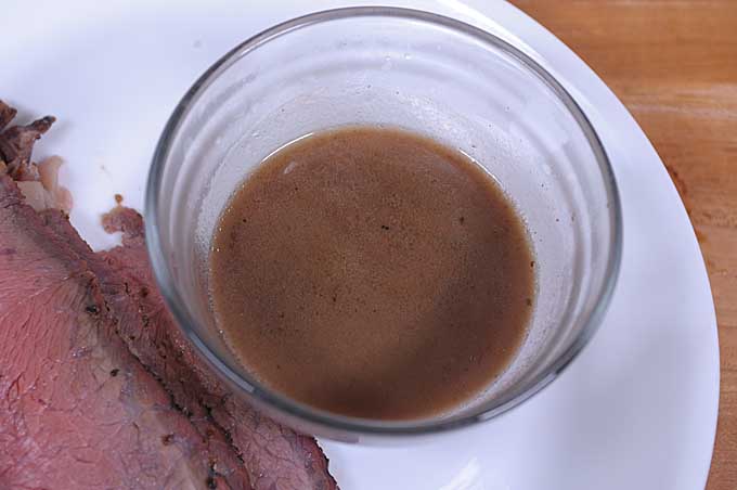 Au jus sauce in a glass bowl | Foodal
