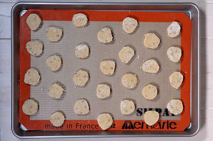 Top view of slices of cookie dough on a Silpat liner on a cookie sheet | Foodal