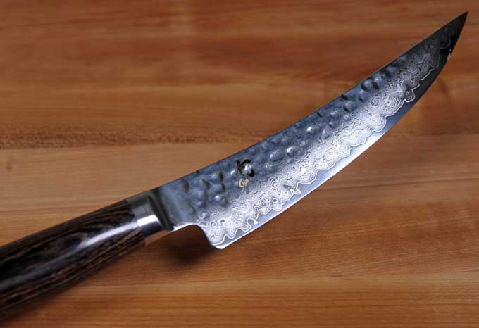 A Shun Premier Gokujo Boning Knife on a wooden cutting board | Foodal