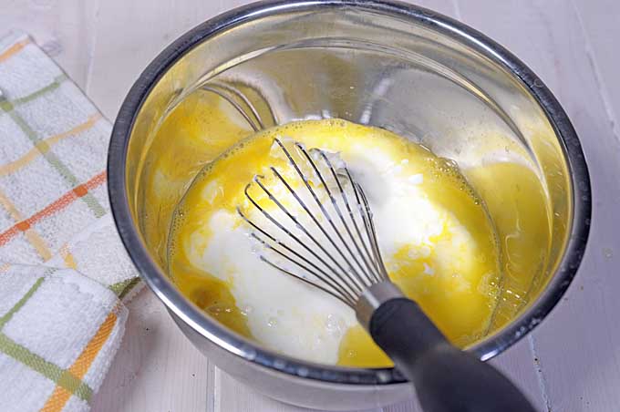 The wet ingrients are bing mixing in a small glass mixing bowl using a balloon whisk | Foodal