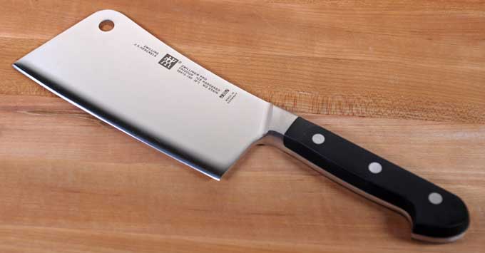 Zwilling Pro 6-Inch Light-weight Meat Cleaver on a maple wooden cutting block.